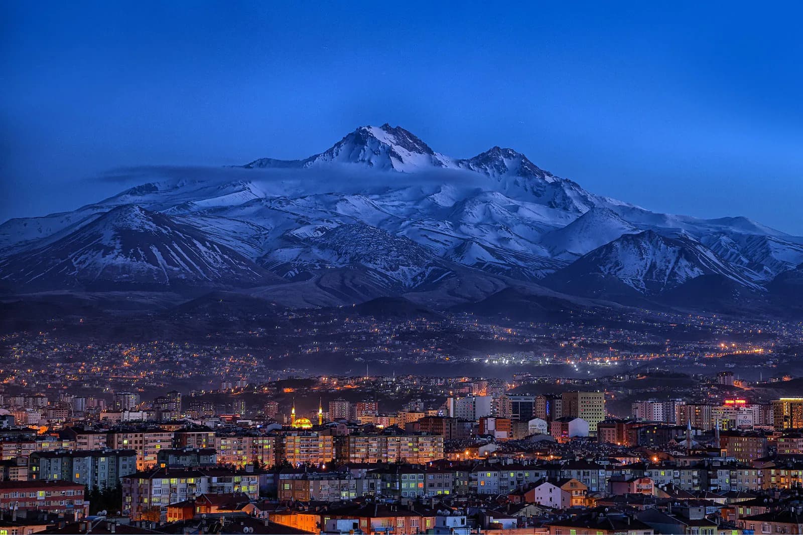 Gece vakti karlı Erciyes Dağı ve Kayseri şehir ışıkları