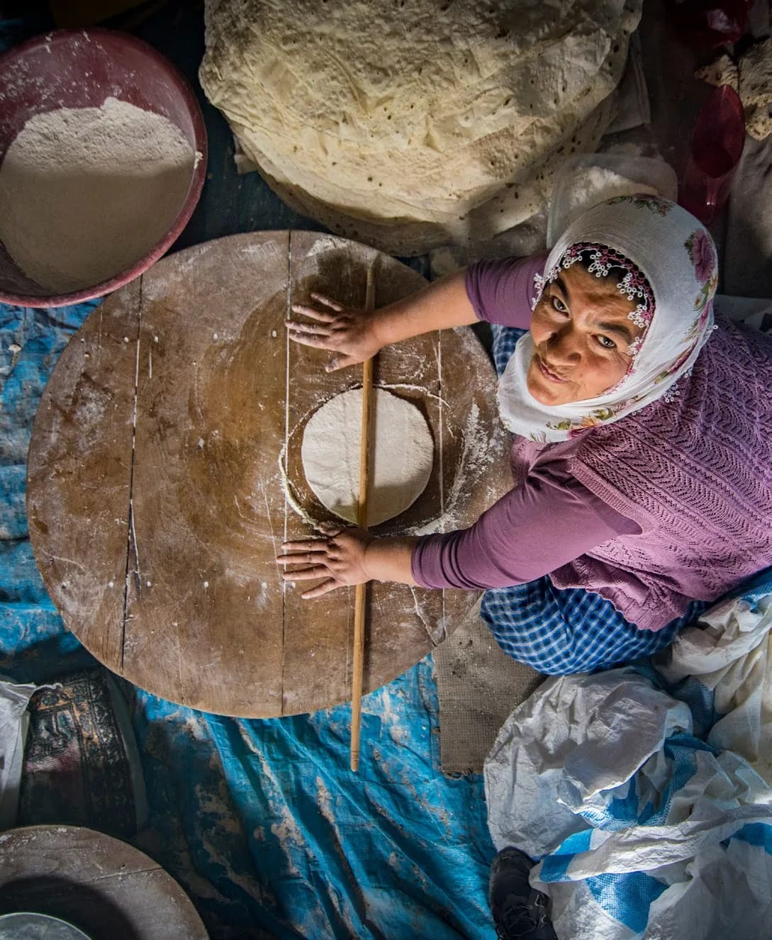 Yer tahtasında oklavayla yufka açan kadın